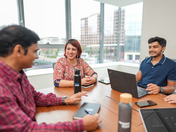 Colleagues discussing work in a modern office.